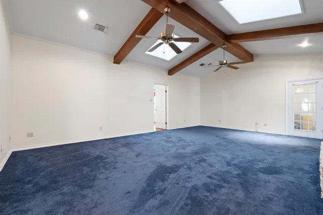 an empty room with a ceiling fan and window
