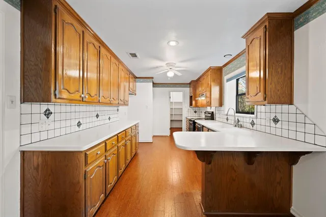 a kitchen with kitchen island a sink and a large window