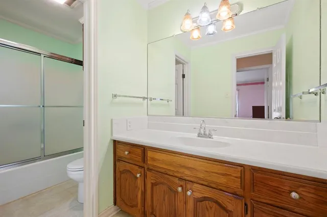a bathroom with a granite countertop sink a toilet and a mirror