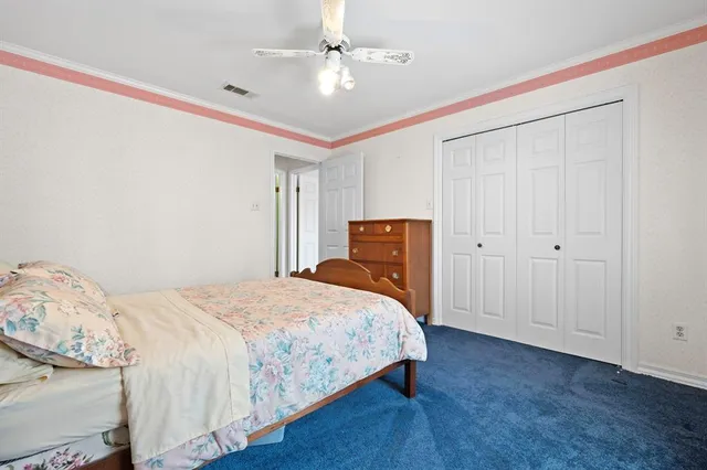 a bedroom with a bed and a ceiling fan