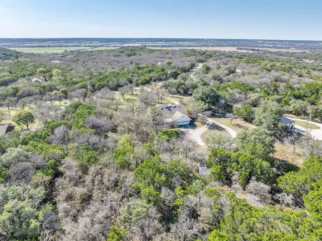 an aerial view of residential houses with outdoor space and trees