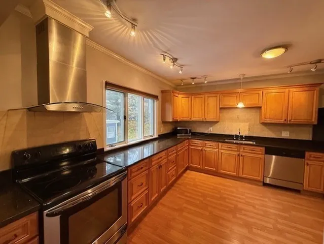 a large kitchen with stainless steel appliances a large counter top