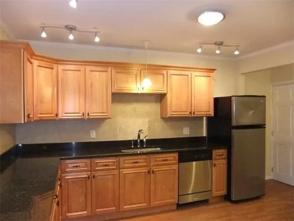 a kitchen with granite countertop a refrigerator a sink a stove a microwave a counter top and cabinets