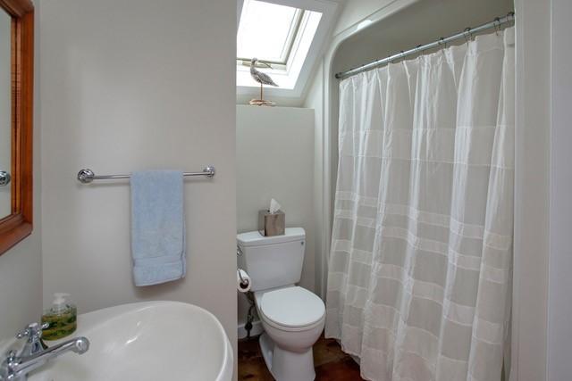 21 Milestone Way Mashpee, MA 02649 - Photo 22 of 27 a white toilet sitting next to a bathroom sink and a shower curtain