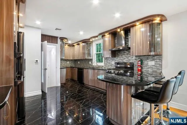 a kitchen with stainless steel appliances granite countertop a sink stove and refrigerator