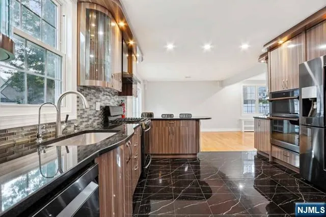 a kitchen with stainless steel appliances a sink stove and cabinets