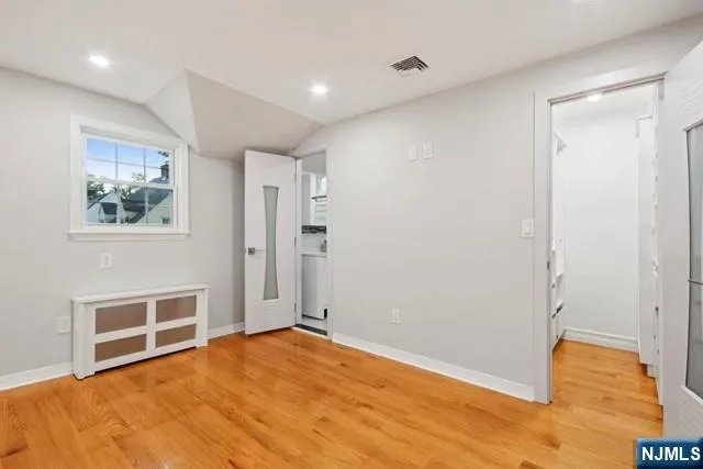 a view of empty room with wooden floor
