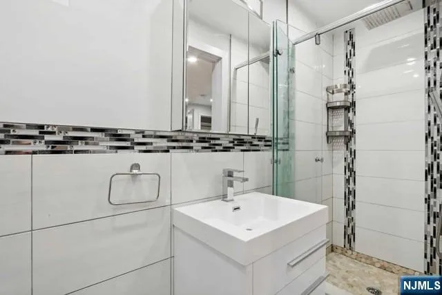 a bathroom with a sink a mirror and a shower