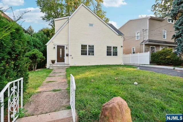 a front view of house with a garden and yard