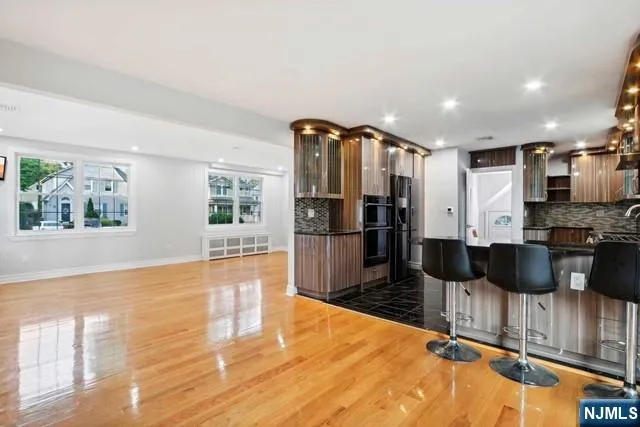 a open kitchen with stainless steel appliances kitchen island granite countertop a refrigerator and microwave