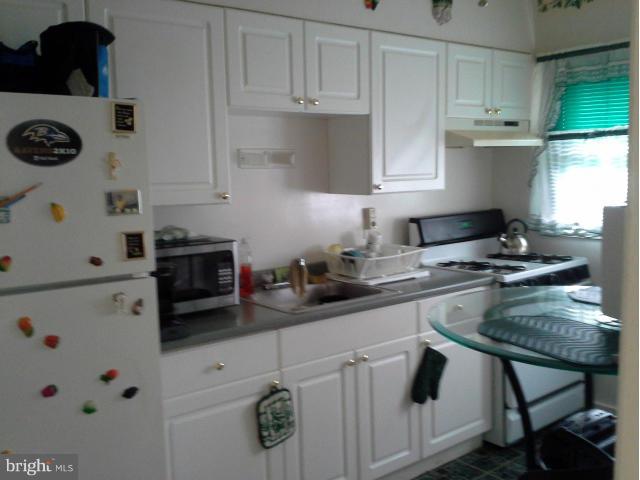 1315 Stonewood Road Baltimore, MD 21239 - Photo 8 of 21 a kitchen with a white cabinets and white appliances