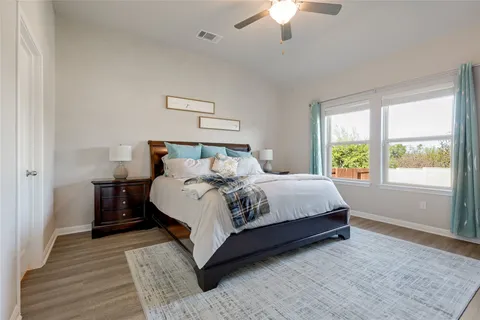 a bedroom with a large bed wooden floor and window