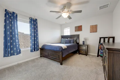 a bedroom with a bed lamp and a large window