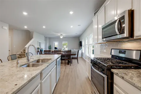 a kitchen with stainless steel appliances granite countertop a sink stove and microwave