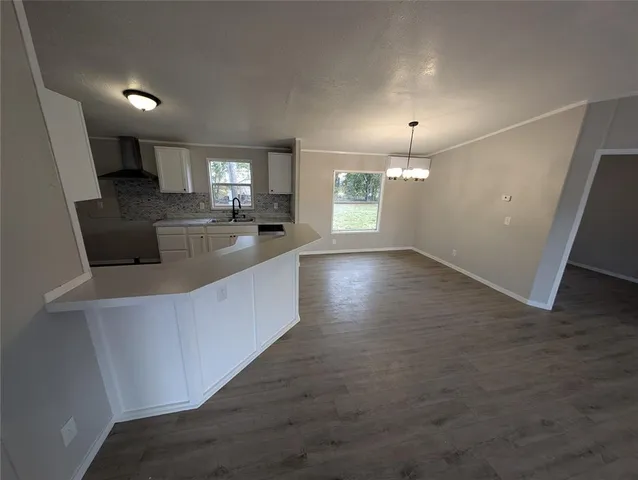 an open kitchen with a sink and dishwasher a stove top oven with wooden floor