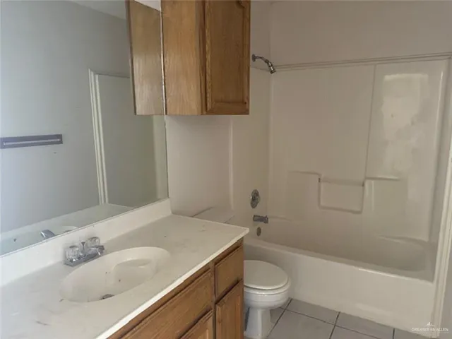 an empty room with wooden floor cabinet and windows