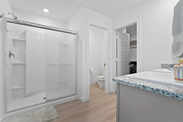 a bathroom with a granite countertop sink mirror and shower
