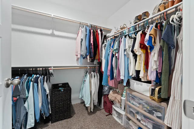 a view of walk in closet with clothes