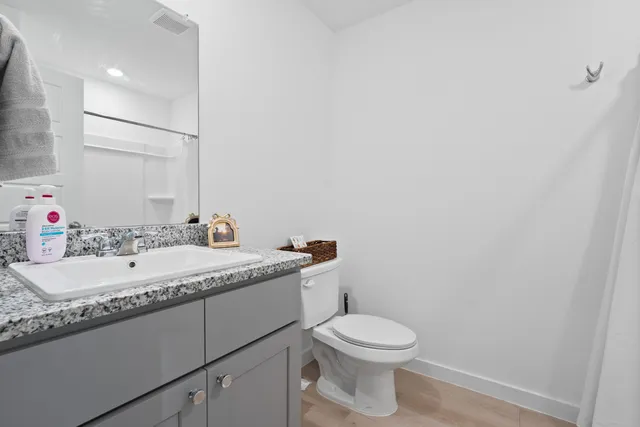 a bathroom with a granite countertop sink and a mirror