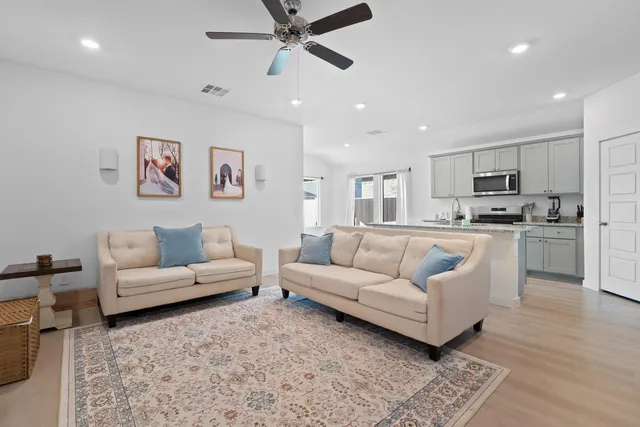 a living room with furniture and a view of kitchen