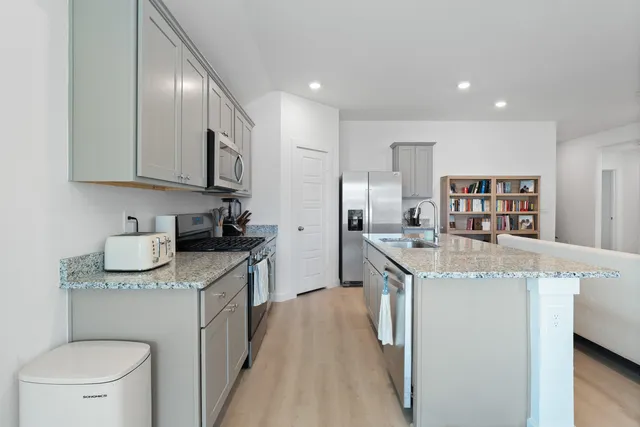 a kitchen with stainless steel appliances granite countertop a sink and stove