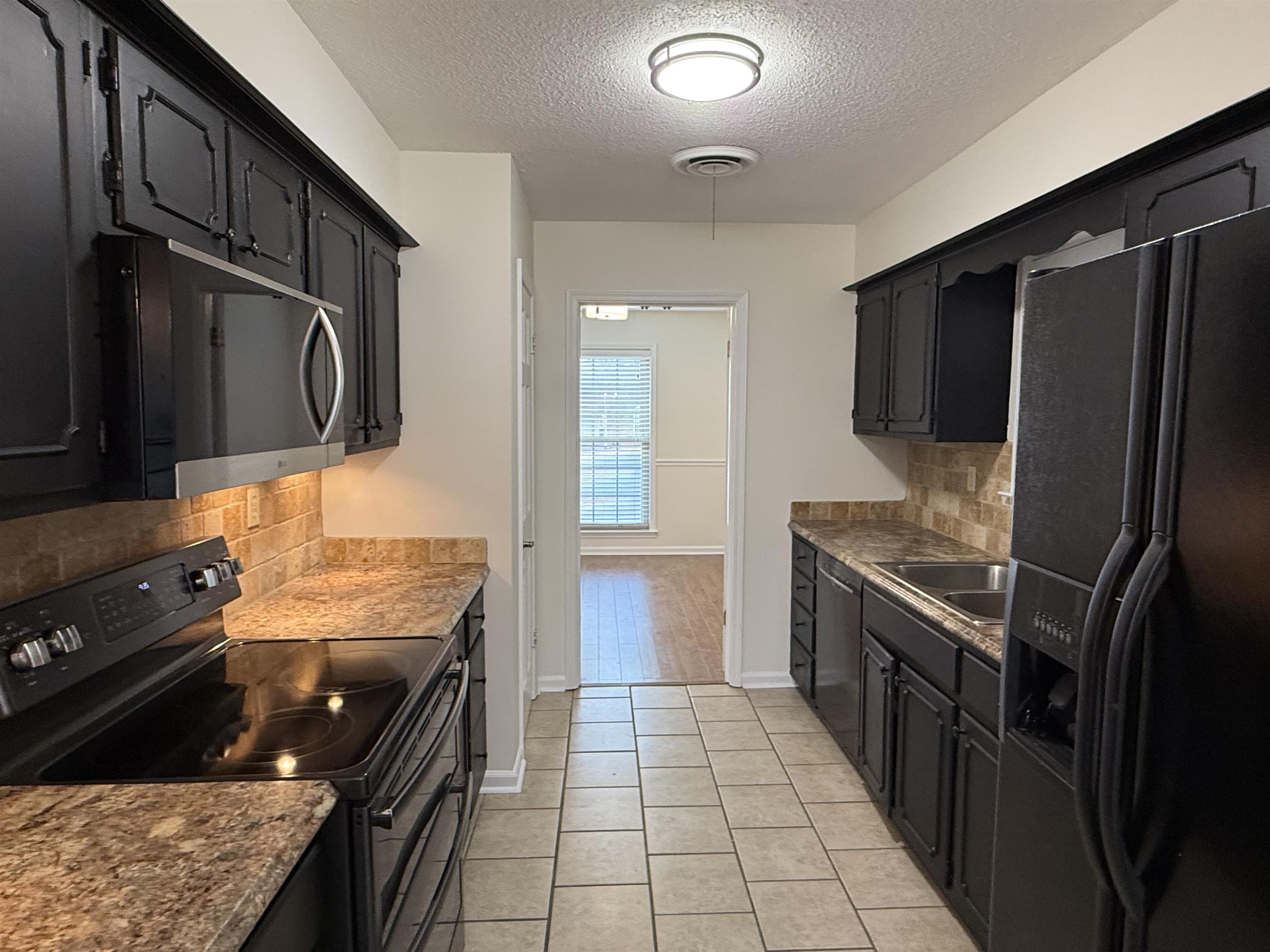 2639 Cedar Ridge Drive Germantown, TN 38138 - Photo 6 of 17 a kitchen with granite countertop a stove and a refrigerator