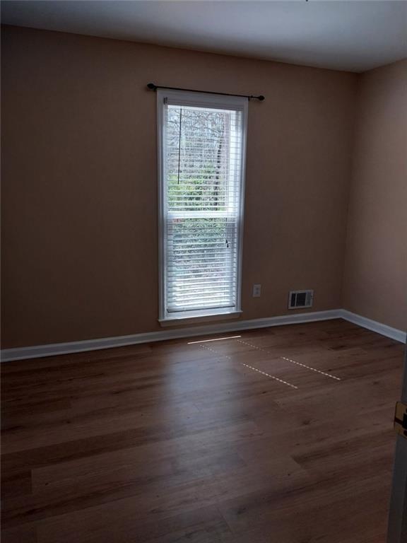 4820 Westbourne Drive Powder Springs, GA 30127 - Photo 13 of 16 a view of an empty room with wooden floor and a window