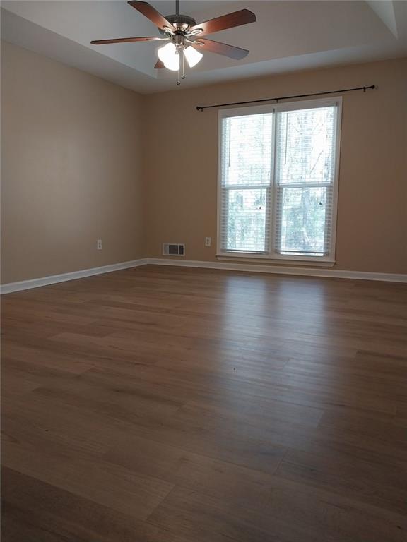 4820 Westbourne Drive Powder Springs, GA 30127 - Photo 14 of 16 an empty room with wooden floor fan and windows