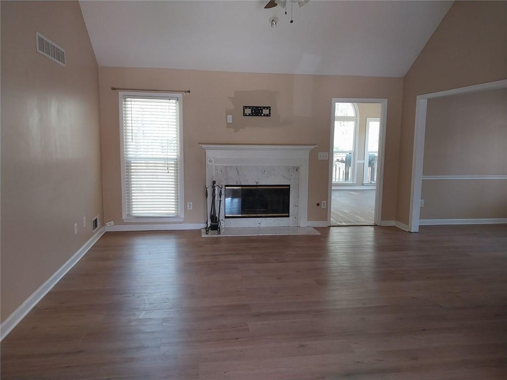 4820 Westbourne Drive Powder Springs, GA 30127 - Photo 2 of 16 an empty room with wooden floor fireplace and windows