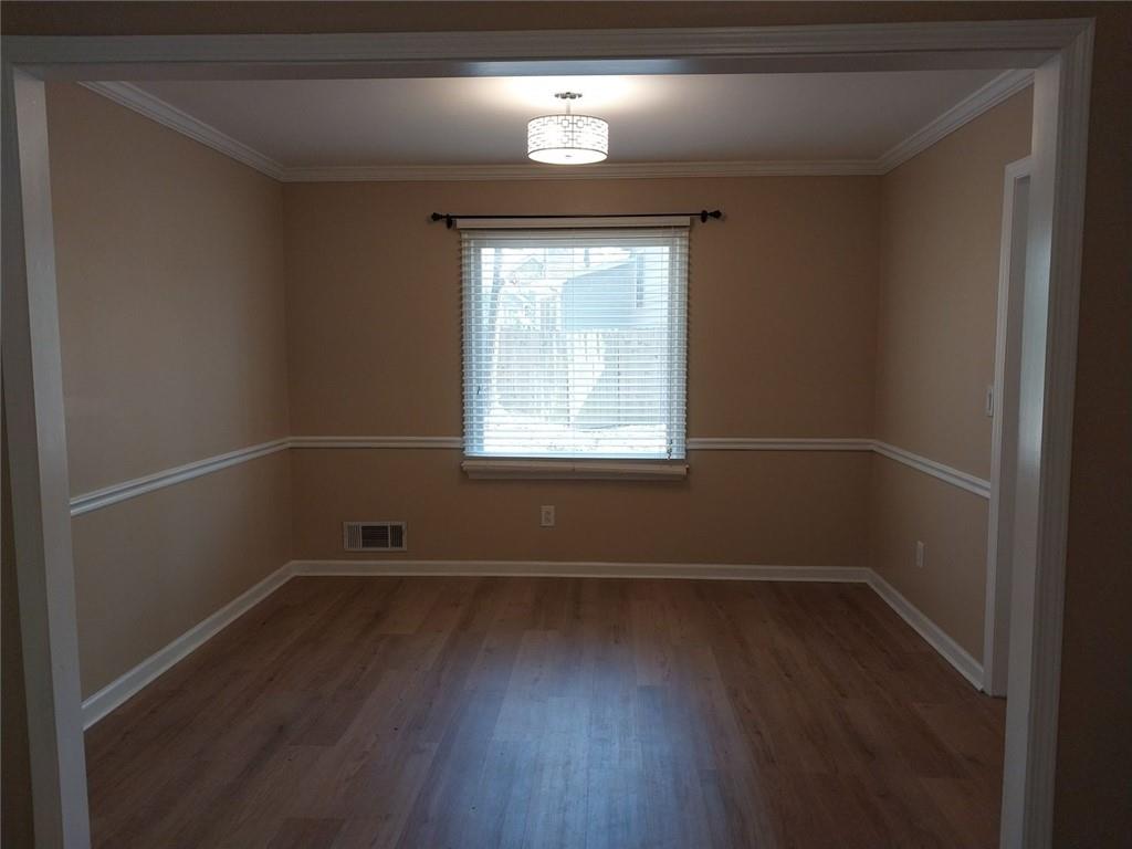 4820 Westbourne Drive Powder Springs, GA 30127 - Photo 5 of 16 an empty room with wooden floor and windows