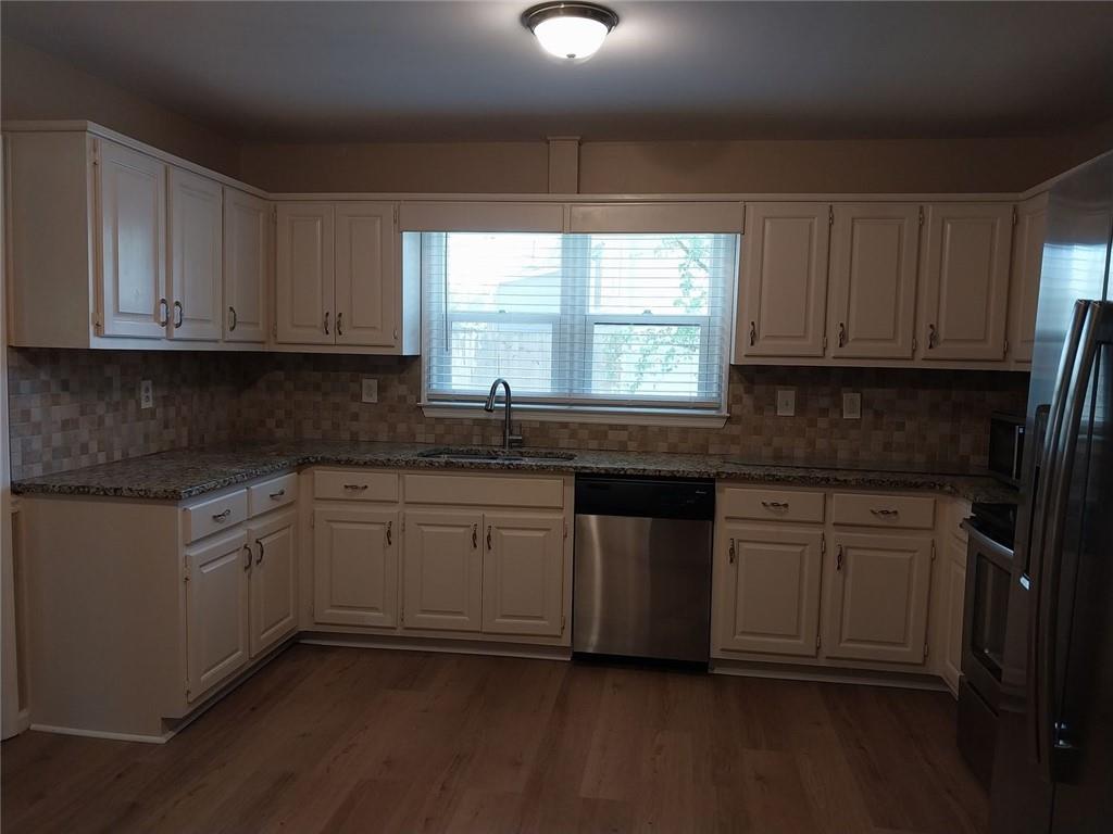 4820 Westbourne Drive Powder Springs, GA 30127 - Photo 6 of 16 a kitchen with granite countertop cabinets stainless steel appliances a sink and a window
