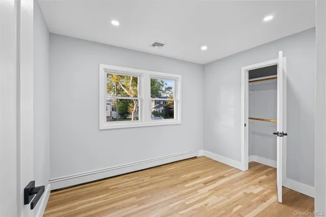 a view of a hallway with wooden floor and closet area