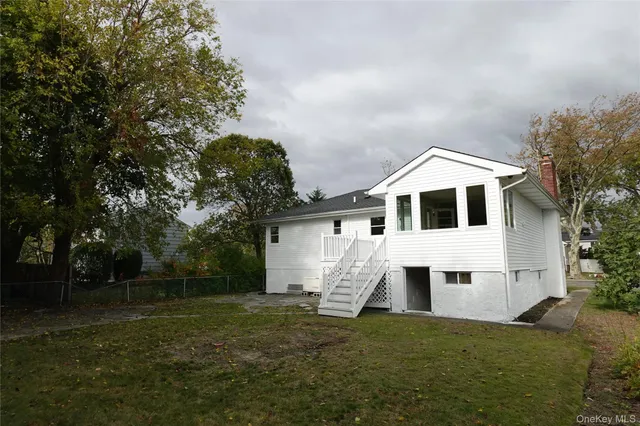 an aerial view of residential houses with outdoor space and trees