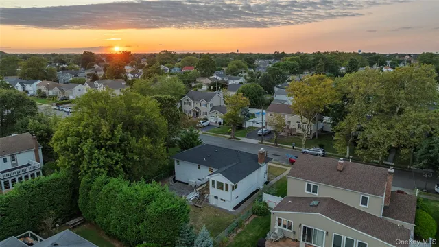 an aerial view of residential houses with outdoor space and trees
