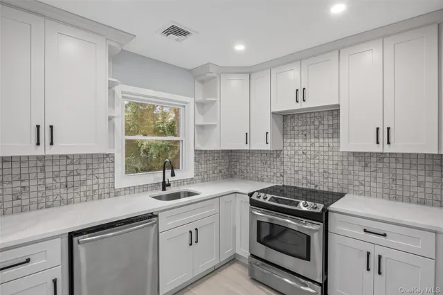 a kitchen with white cabinets and window
