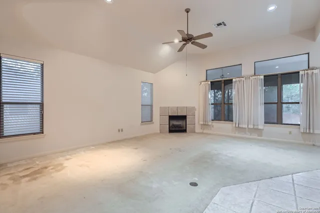 an empty room with fireplace and windows