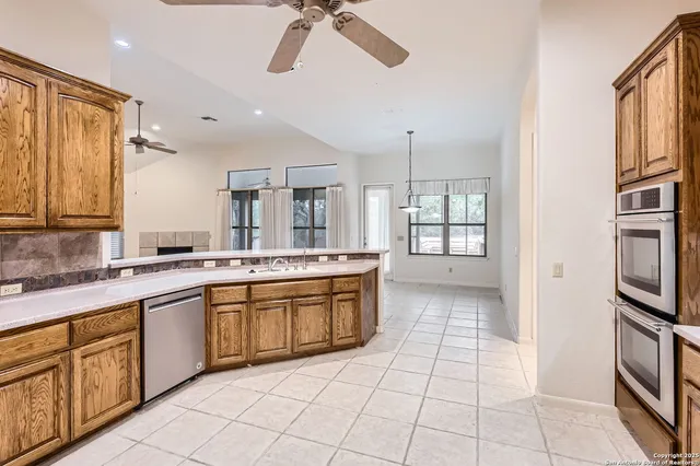 a large kitchen with a stove a sink dishwasher and a refrigerator