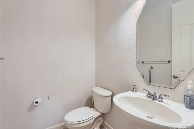 a bathroom with a sink a toilet and mirror