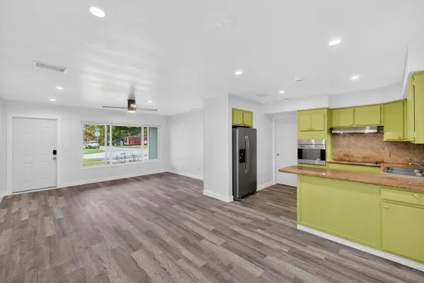 a kitchen with stainless steel appliances granite countertop a refrigerator and a sink