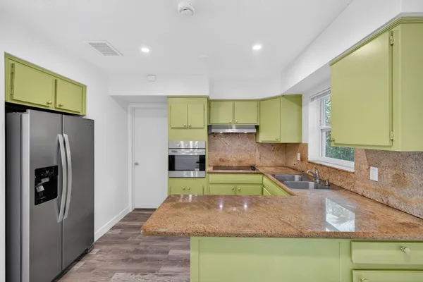 a kitchen with a refrigerator sink and cabinets