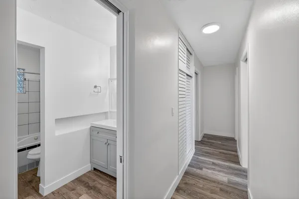 a view of empty room with wooden floor and ceiling fan