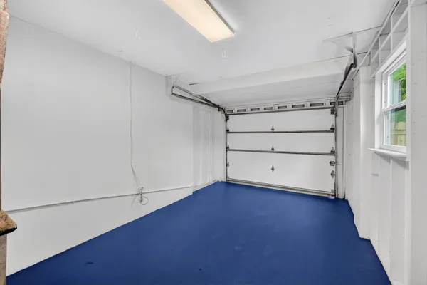 a view of an empty room with wooden floor and a floor to ceiling window