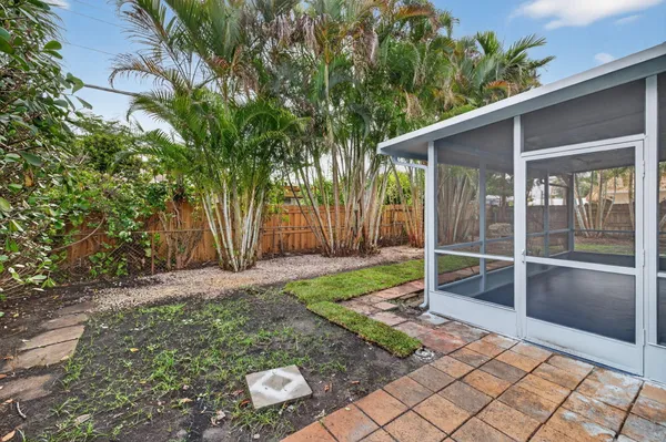 a view of backyard with large trees and wooden fence