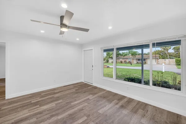 a view of an empty room with wooden floor and a floor to ceiling window
