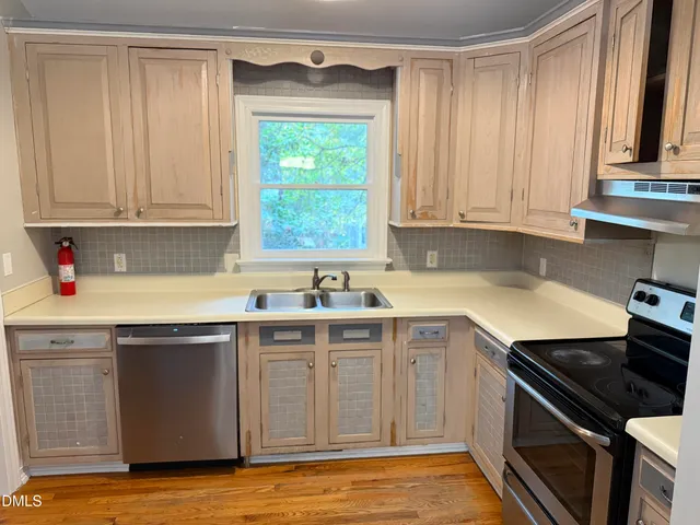 a kitchen with a sink stove top oven and cabinets