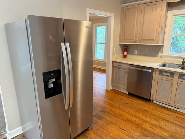 a kitchen with stainless steel appliances granite countertop a refrigerator and a sink