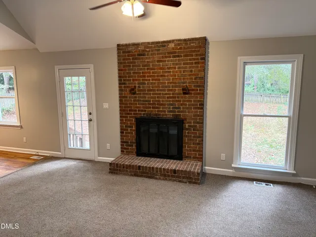 an empty room with fireplace and windows