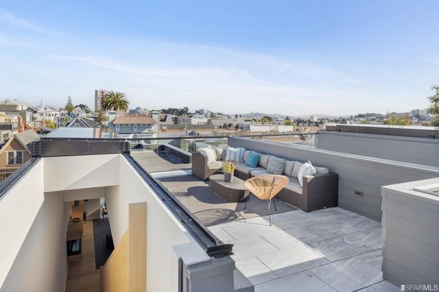 a view of a terrace with furniture and city view