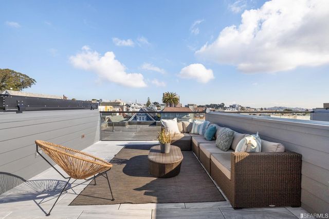 a roof deck with couches and potted plants