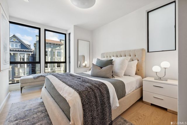 a bedroom with a bed a table and painting on the wall